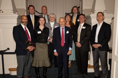group of professionals on a staircase showing off their award plaques